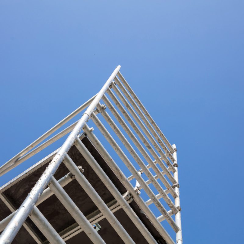 Scaffolding, metal mobile scaffold aginst blue sky background.